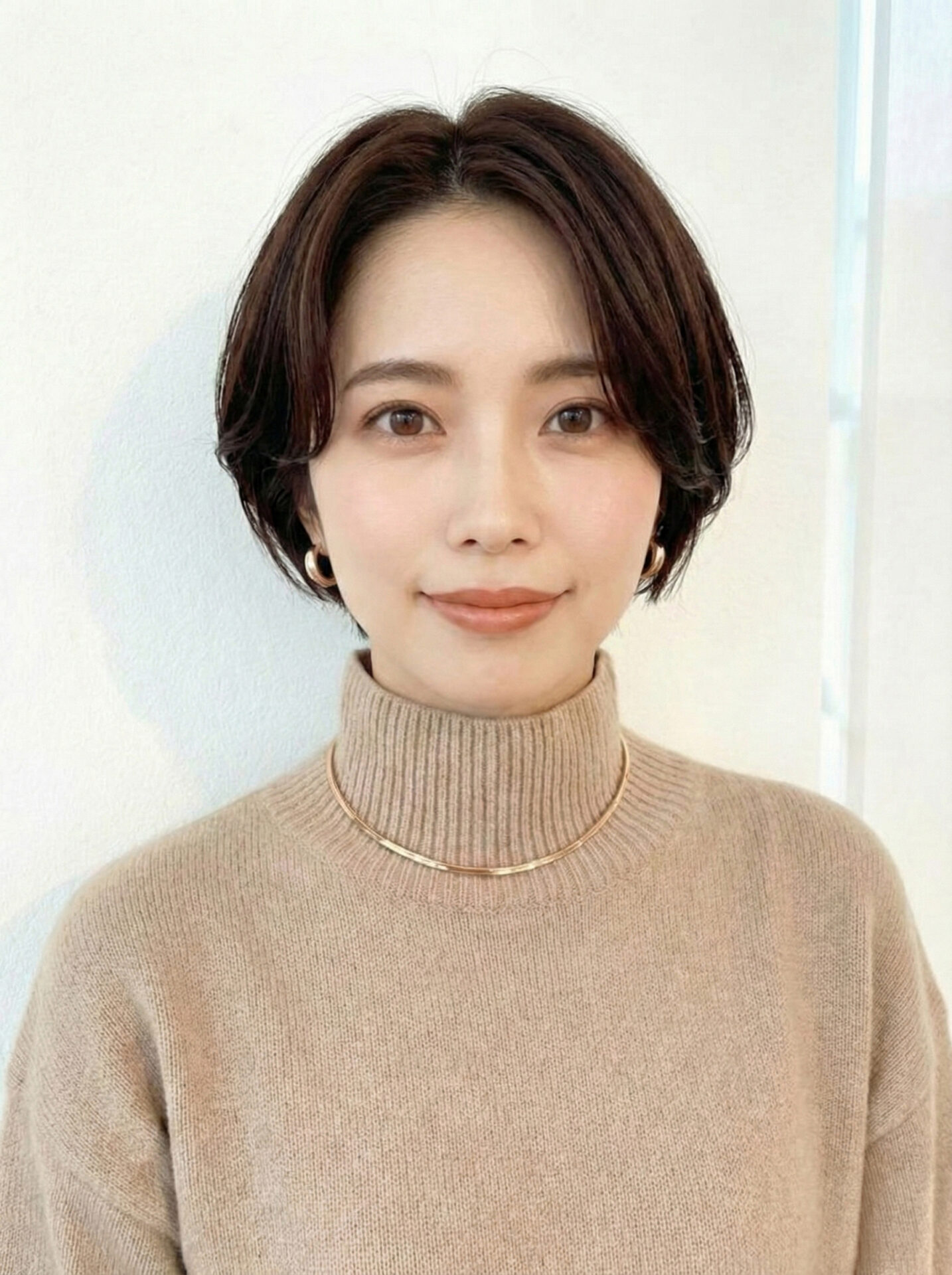 長めの前髪をセンター付近で分けた大人のハンサムショート|顔まわりの柔らかな毛流れ