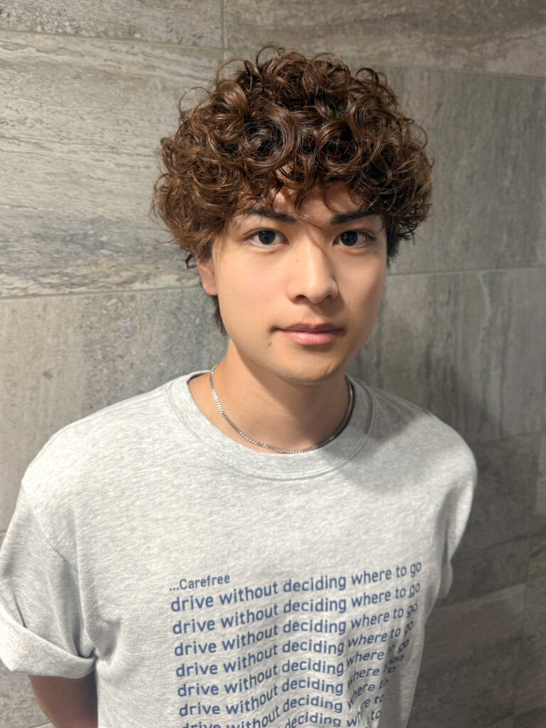 丸みのあるメンズマッシュに細かなスパイラルカールを重ねた、前髪に動きのあるヘアスタイル
