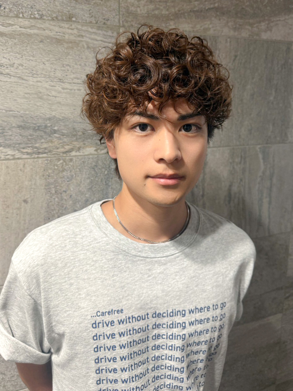 丸みのあるメンズマッシュに細かなスパイラルカールを重ねた、前髪に動きのあるヘアスタイル